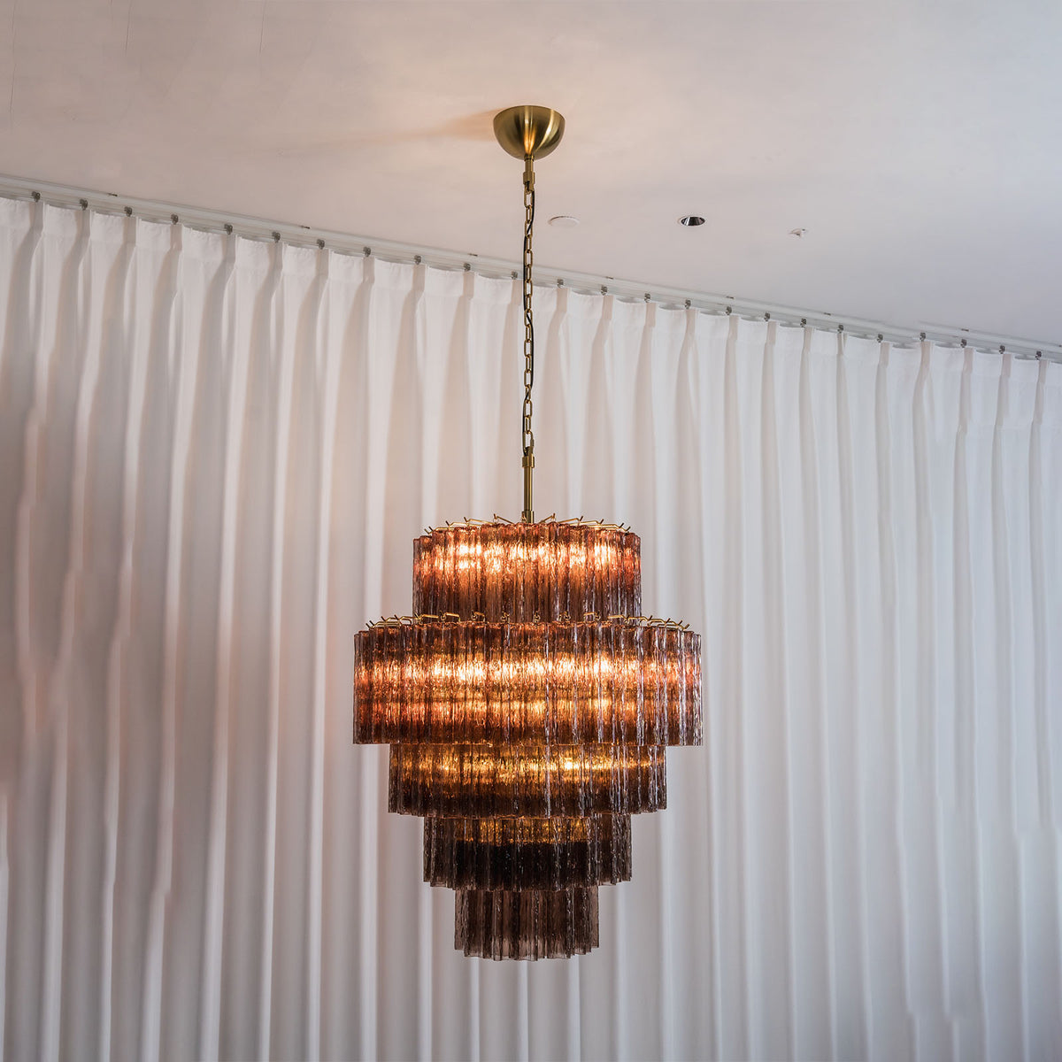 Ottoline Tiered Glass Chandelier | Textured Glass and Brass | Full hanging view displayed elegantly against white sheer curtains | Severn Lighting