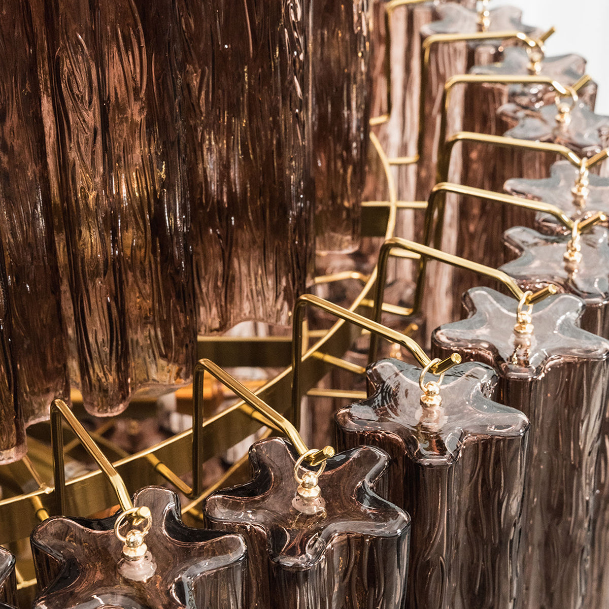Ottoline Tiered Glass Chandelier | Textured Glass and Brass | Close-up view of the brass frame hooks holding the glass rods | Severn Lighting