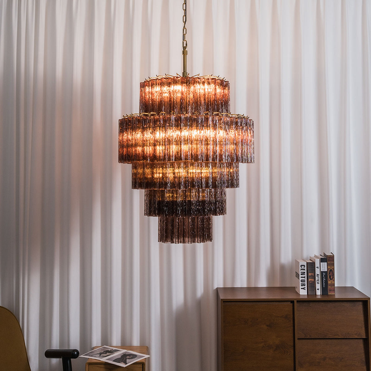 Ottoline Tiered Glass Chandelier | Textured Glass and Brass | Illuminated warmly against a vertical fluted white wall panel | Severn Lighting
