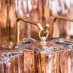 Ottoline Tiered Glass Chandelier | Textured Glass and Brass | Macro detail of a brass hook securely holding a glass element | Severn Lighting