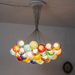 Rainbow Glass Bubble Cluster Chandelier | Multi-colored Blown Glass and Metal Cords | The entire multi-color cluster lit up in a dimly lit room creating a magical warm atmosphere | Severn Lighting