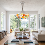 Rainbow Glass Bubble Cluster Chandelier | Multi-colored Blown Glass and Metal Cords | Hanging in a spacious modern living room with a cream sofa and large windows overlooking trees | Severn Lighting