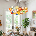 Rainbow Glass Bubble Cluster Chandelier | Multi-colored Blown Glass and Metal Cords | Styled over a round dining table next to bright white French doors opening to a garden | Severn Lighting
