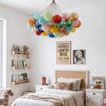 Rainbow Glass Bubble Cluster Chandelier | Multi-colored Blown Glass and Metal Cords | Casting a warm glow in a cozy bohemian style bedroom with a wooden bed and patterned bedding | Severn Lighting