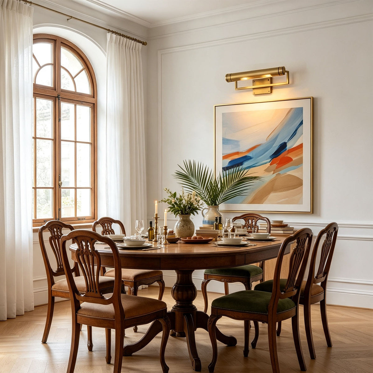 Redmond Brass Picture Wall Lamp | Brass and Metal | Centered above wall artwork in a bright dining room with a wooden table | Severn Lighting