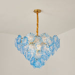 Rosalind Petal Glass Chandelier | Textured Spiral Blue Glass and Gold Metal | Minimalist view of the glowing blue chandelier hanging from a plaster ceiling in a room | Severn Lighting