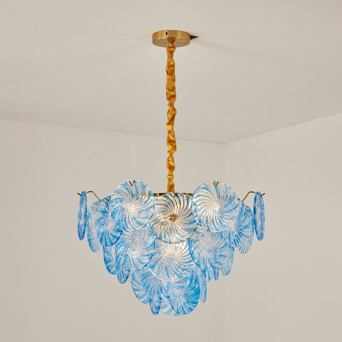 Rosalind Petal Glass Chandelier | Textured Spiral Blue Glass and Gold Metal | Full studio product shot of the illuminated blue tiered light fixture on a plain background | Severn Lighting