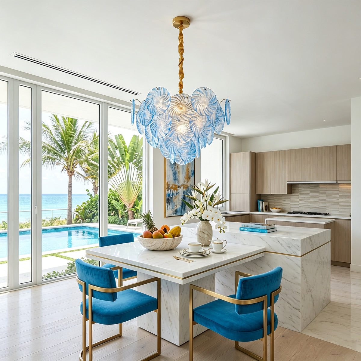 Rosalind Petal Glass Chandelier | Textured Spiral Blue Glass and Gold Metal | Styled over a white marble kitchen island with vibrant blue velvet bar stools | Severn Lighting