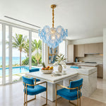 Rosalind Petal Glass Chandelier | Textured Spiral Blue Glass and Gold Metal | Styled over a white marble kitchen island with vibrant blue velvet bar stools | Severn Lighting