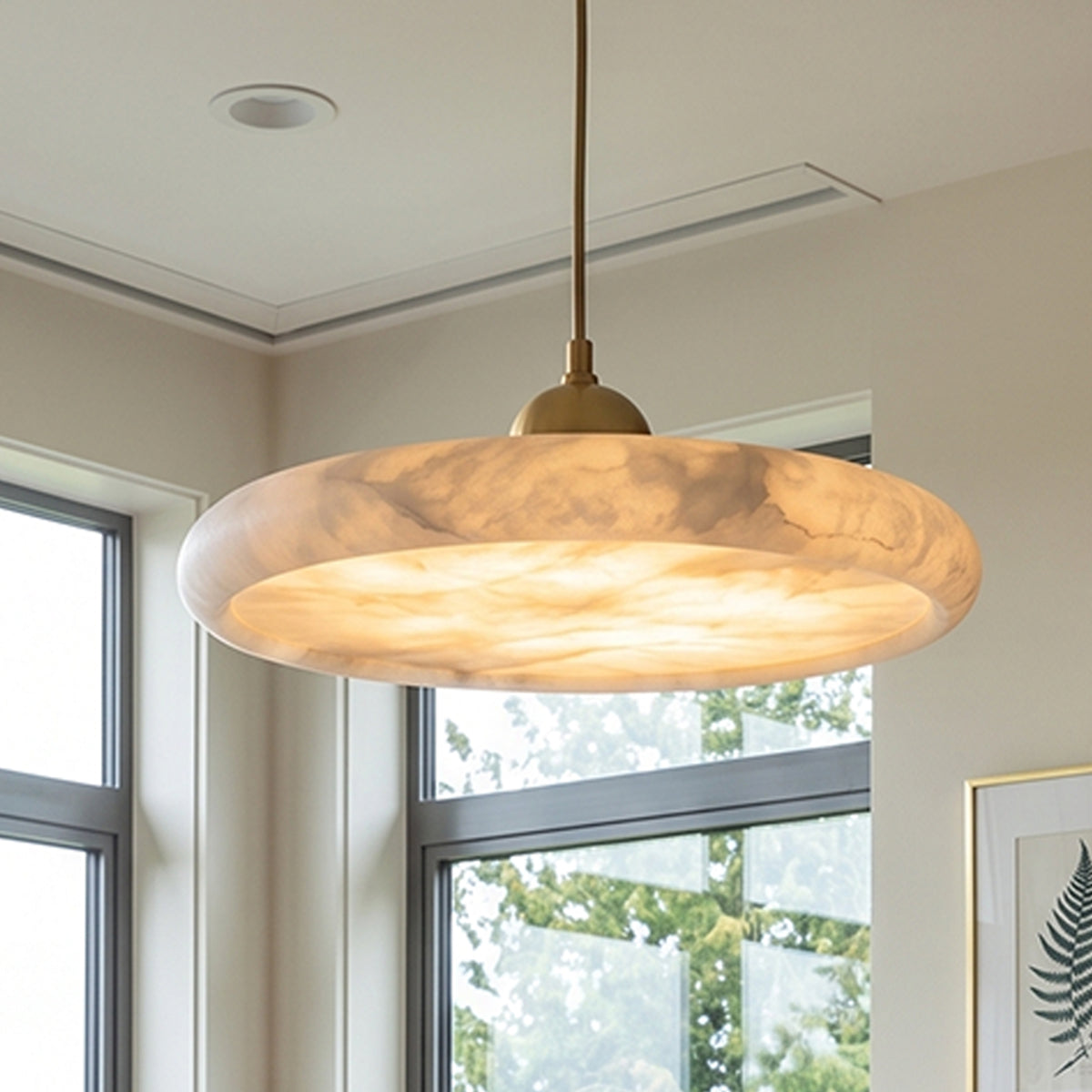Sabine Alabaster Disc Pendant Light | Natural Alabaster and Brass | Enhancing a modern dining room featuring glass patio sliding doors | Severn Lighting