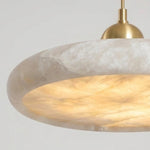 Sabine Alabaster Disc Pendant Light | Natural Alabaster and Brass | Angled close-up highlighting the glowing underside and brass cap | Severn Lighting