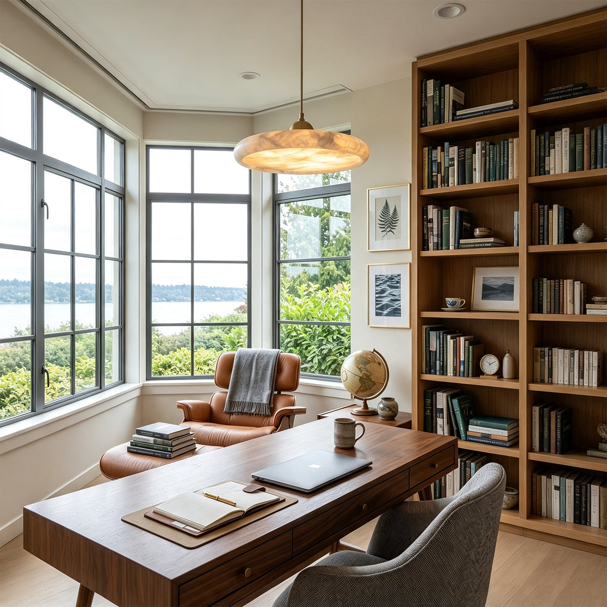 Sabine Alabaster Disc Pendant Light | Natural Alabaster and Brass | Illuminating a wooden desk in a home office with tall bookshelves | Severn Lighting