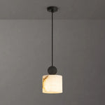 Sabine Alabaster Drum Pendant Light | Natural Alabaster and Brass | Symmetrical view of the drum stone fixture fully illuminated against a charcoal grey background | Severn Lighting