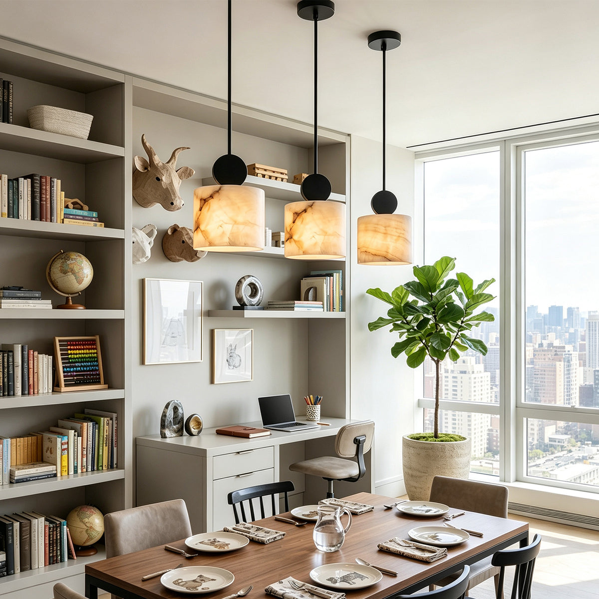 Sabine Alabaster Drum Pendant Light | Natural Alabaster and Brass | Multiple fixtures hanging over a long wooden dining or study table next to a large library bookshelf | Severn Lighting