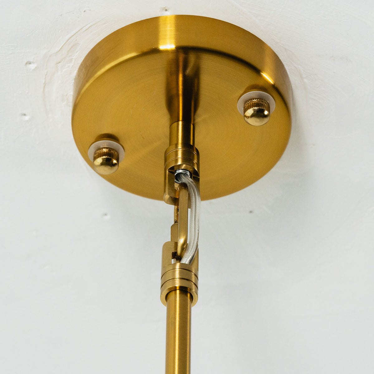 Semoy Curved Glass Petal Pendant Light | Curved Glass and Brass | Close-up detail view of the brass ceiling canopy and hanging rod assembly | Severn Lighting