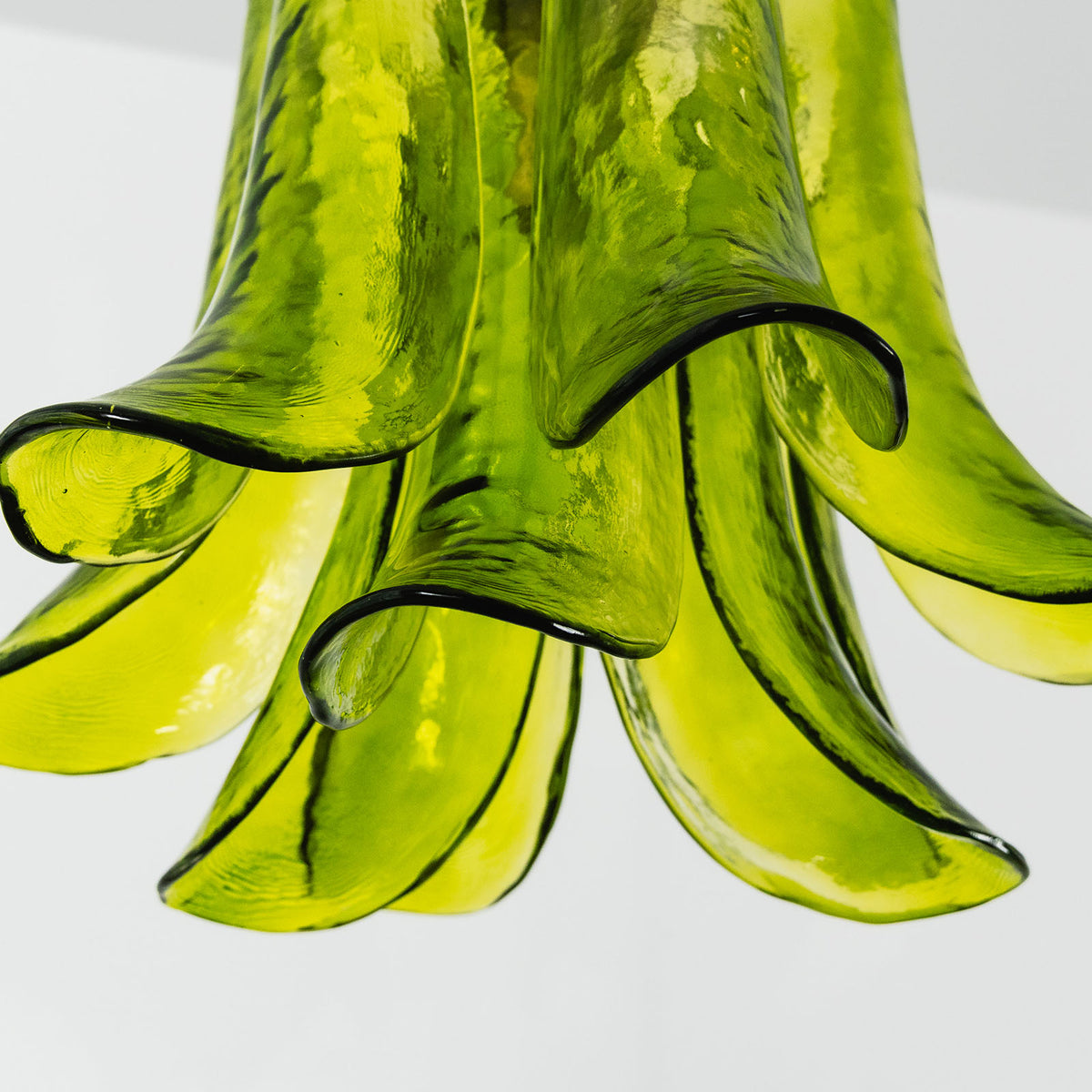 Semoy Curved Glass Petal Pendant Light | Curved Glass and Brass | Close-up view of the lower flared tips of the green glass petal shade | Severn Lighting