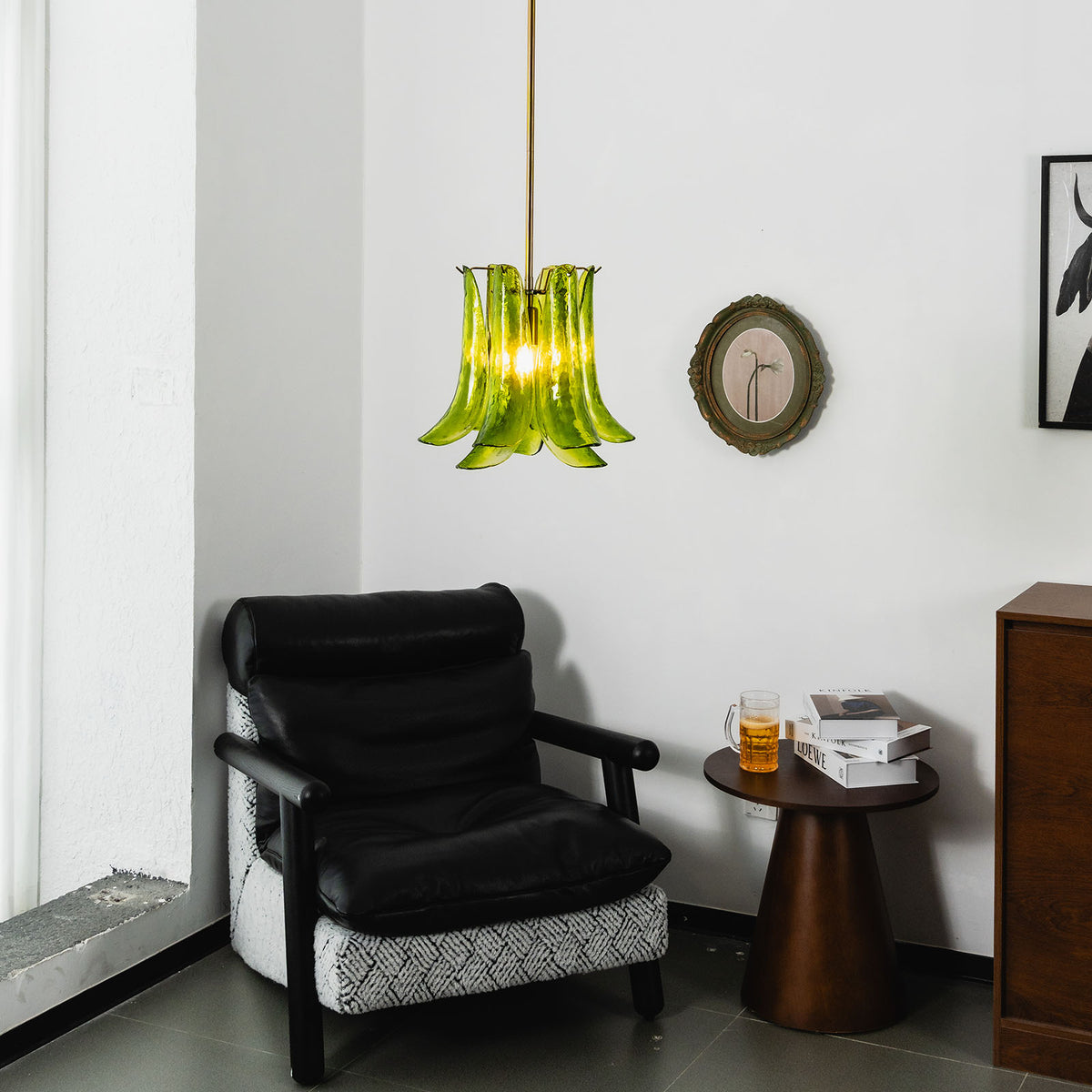 Semoy Curved Glass Petal Pendant Light | Curved Glass and Brass | Lighting a room corner beside a black leather armchair | Severn Lighting