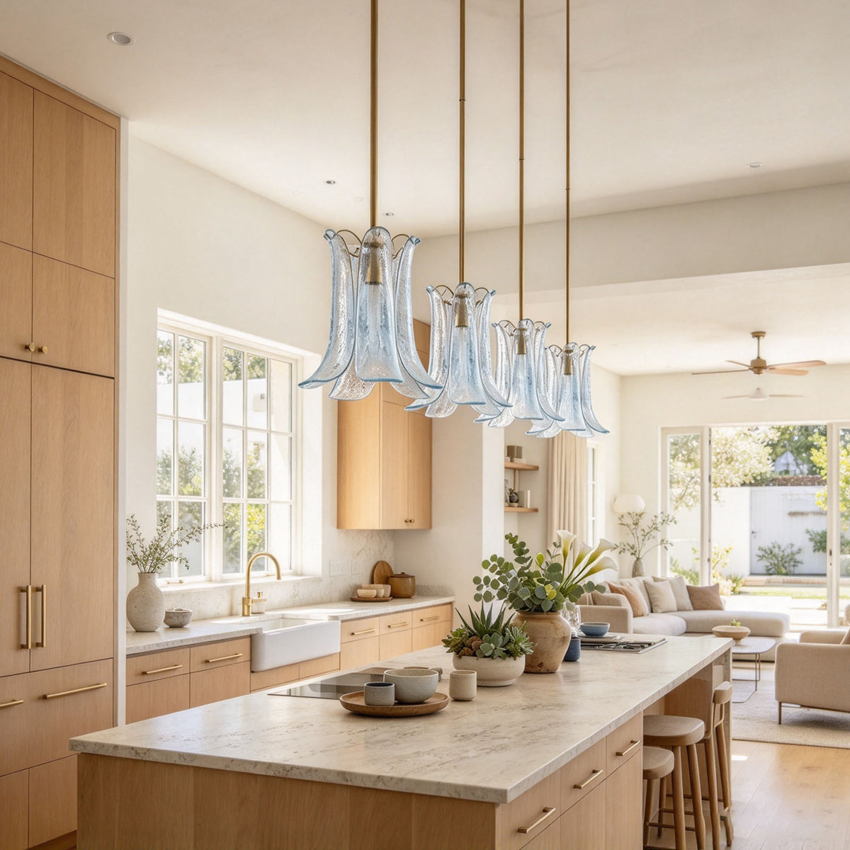 Semoy Curved Glass Petal Pendant Light | Curved Glass and Brass | Trio of clear glass pendant lights displayed over a kitchen island | Severn Lighting