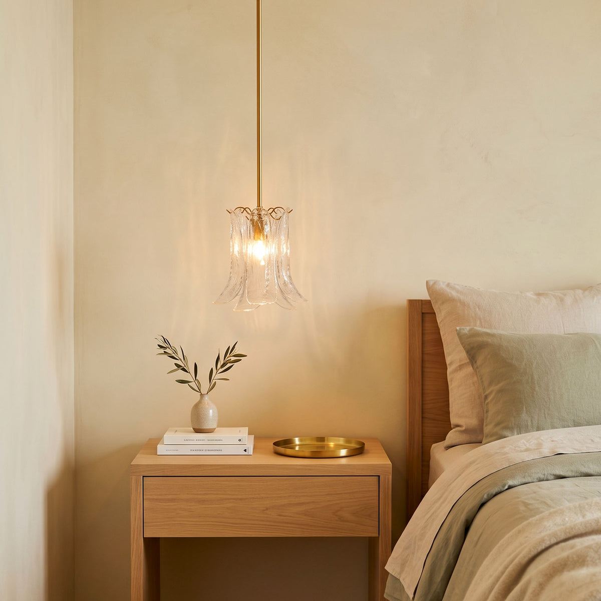 Semoy Curved Glass Petal Pendant Light | Curved Glass and Brass | Single pendant light hanging beside a bed over a wooden nightstand | Severn Lighting