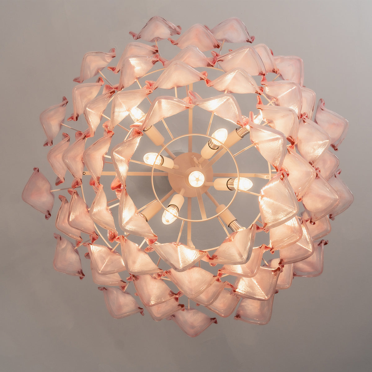 Seraphina Rose Glass Petal Chandelier | Glass, Metal | Direct bottom-up internal perspective view looking into the radial concentric layers of lit pink glass petals and frame bulbs | Detail shot | Severn Lighting