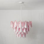 Seraphina Rose Glass Petal Chandelier | Glass, Metal | Staged unlit view of the pink glass fixture hanging elegantly in a clean minimalist living space above a white fireplace mantle | Severn Lighting