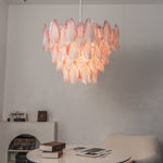 Seraphina Rose Glass Petal Chandelier | Glass, Metal | Staged in a contemporary minimalist dining alcove corner, projecting a soft glow over a round white lounge table | Severn Lighting