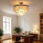 Sirena Capiz Disc Tiered Ceiling Light | Shell, Metal | Adding a warm ambient glow to a traditional home office with a dark wood desk and library bookshelves | Samu Lamp