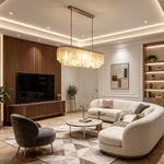 Sirena Capiz Elongated Linear Chandelier | Capiz Shell, Metal | Providing a warm golden glow over a modern luxury living room with a white curved sofa and wood paneling | Samu Lamp