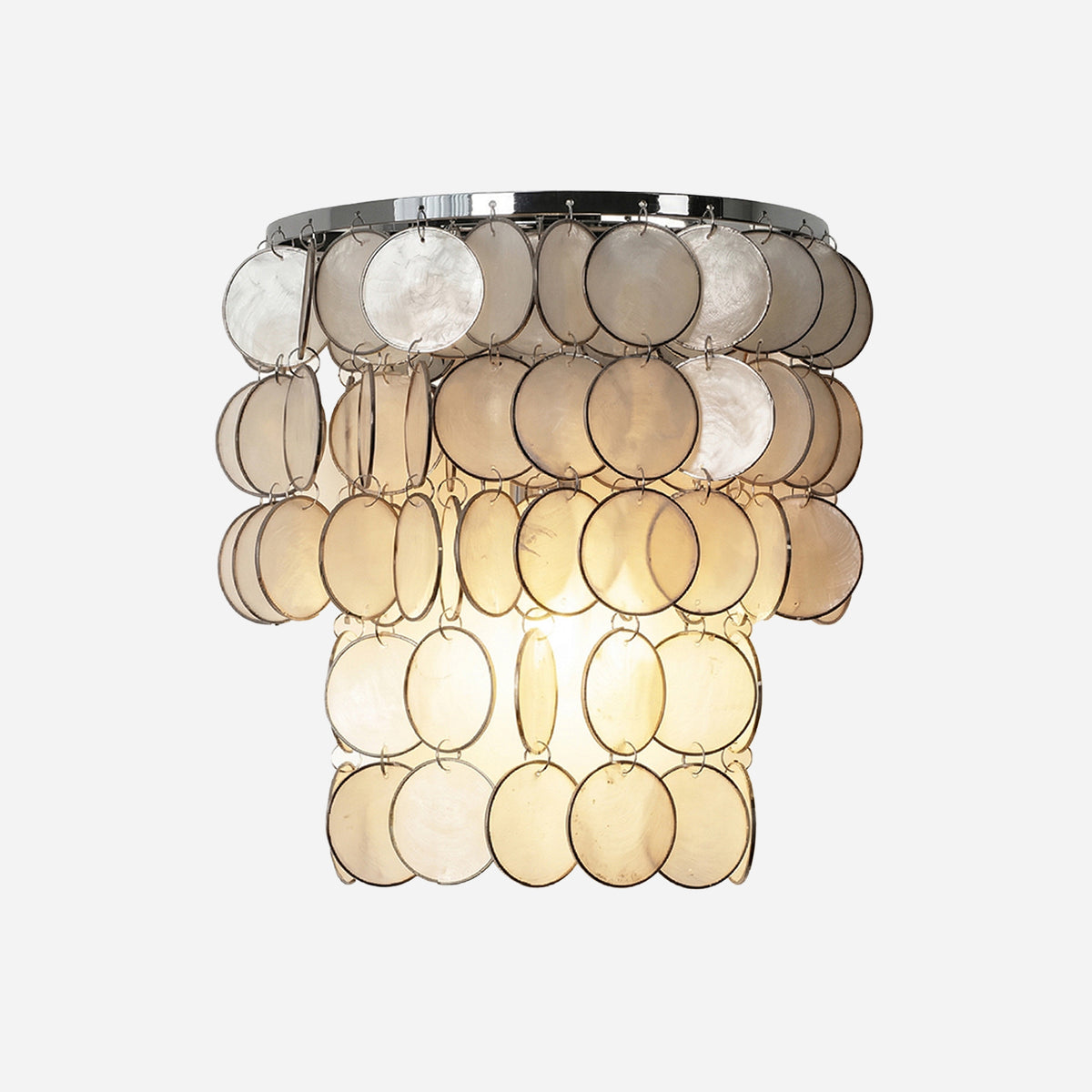 Sirena Capiz Tiered Wall Sconce | Capiz Shell, Metal | Half-drum tiered wall sconce featuring cascading translucent capiz shell discs and a polished chrome frame | Isolated lit product shot on white background | Samu Lamp