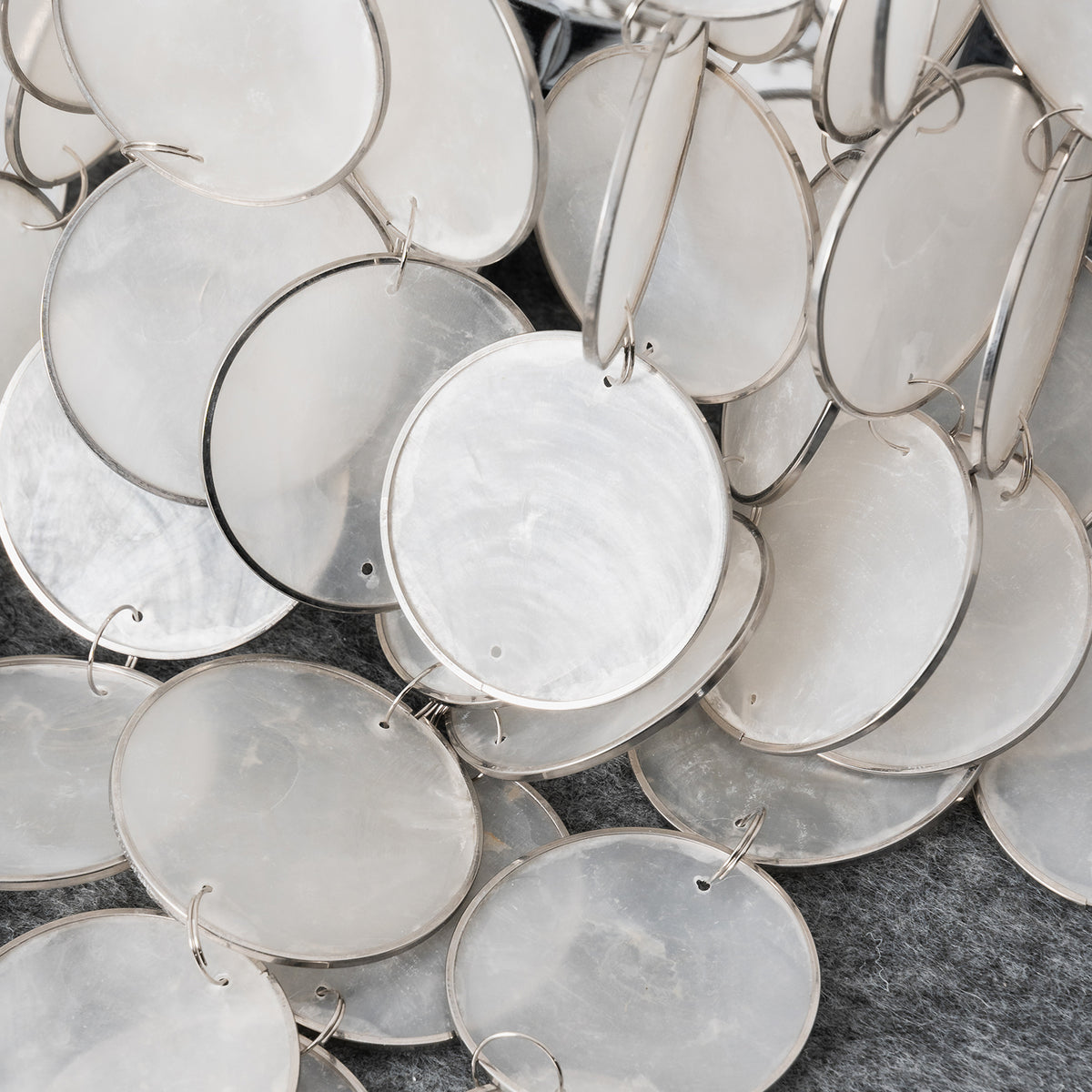 Sirena Capiz Tiered Wall Sconce | Capiz Shell, Metal | Macro close-up view of the natural, pearlescent overlapping capiz shell discs | Detail shot | Samu Lamp