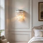 Sirena Capiz Tiered Wall Sconce | Capiz Shell, Metal | Wall-mounted in a cozy bedroom corner next to a soft upholstered headboard | Samu Lamp