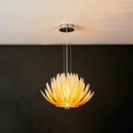 Solaris Agave Glass Starburst Chandelier | Amber Textured Glass | Hanging fully lit on slim suspension wires against a dramatic dark grey backdrop | Severn Lighting