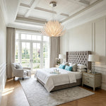 Solaris Agave Glass Starburst Chandelier | Amber Textured Glass | Hanging in a luxurious master bedroom above a grey tufted bed with high windows | Severn Lighting