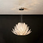 Solaris Agave Glass Starburst Chandelier | White Textured Glass | Frontal view of the glowing white glass agave fixture on a solid dark charcoal wall | Severn Lighting