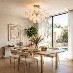 Solene Clustered Glass Disc Ceiling Light | Clear and Frosted Glass Discs | Casting a warm glow in a bright living room featuring a fireplace and a pool view window | Severn Lighting
