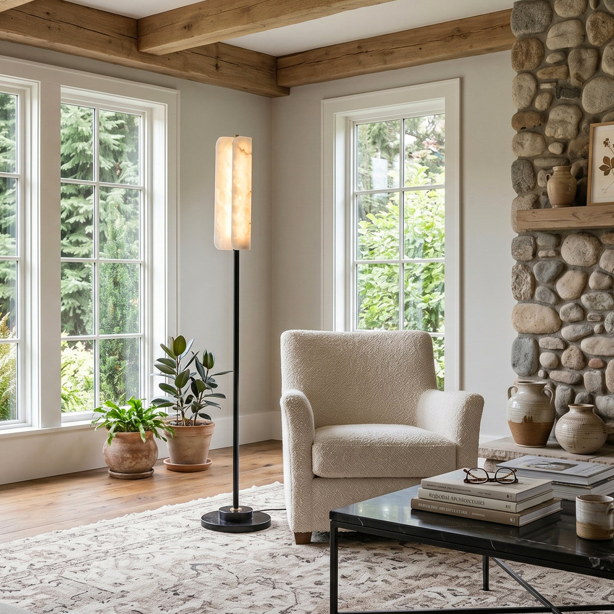 Stellan Alabaster Column Floor Lamp | Natural Alabaster, Brass and Black Metal | Illuminating a rustic living room with a fireplace and armchair | Severn Lighting