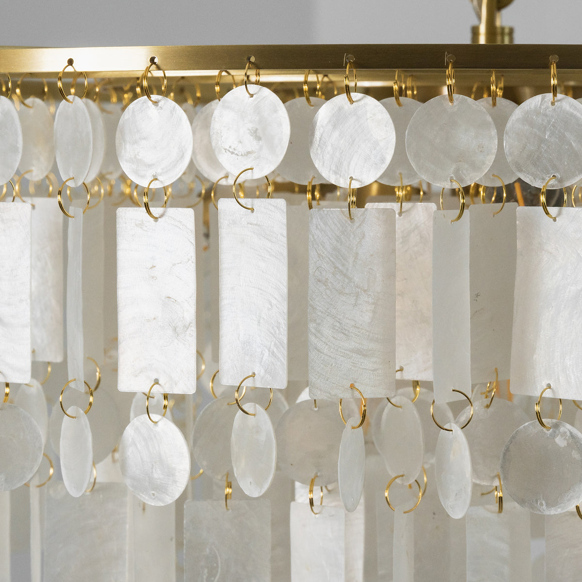 Thalassa Tiered Capiz Shell Chandelier | Capiz Shell, Metal | Detailed close-up view highlighting the organic variations and translucent white texture of the hanging rectangular capiz panels | Detail shot | Severn Lighting