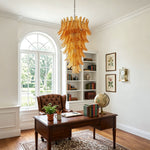 Thessaly Amber Glass Plume Chandelier | Amber Glass and Brass | Centered in a home office with a wooden desk and arched window | Severn Lighting