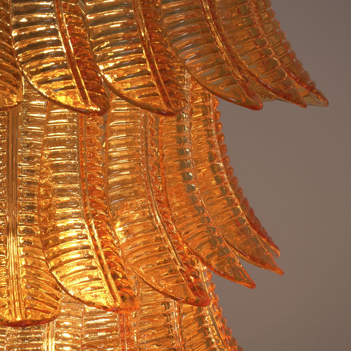 Thessaly Amber Glass Plume Chandelier | Amber Glass and Brass | Close-up detail of the layered amber glass plume elements | Severn Lighting