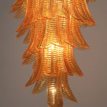 Thessaly Amber Glass Plume Chandelier | Amber Glass and Brass | Medium close-up showing the glowing bottom tiers of the chandelier | Severn Lighting