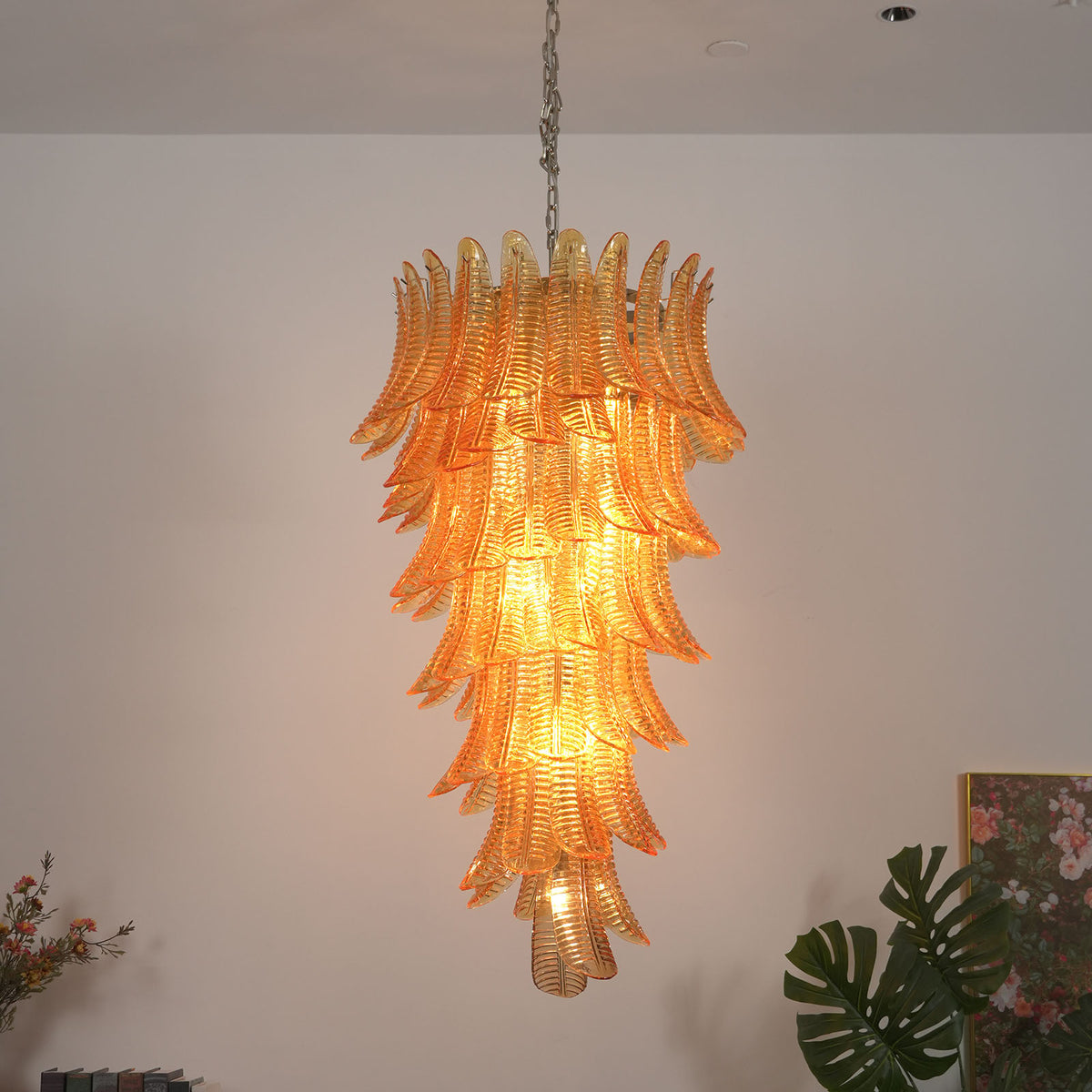 Thessaly Amber Glass Plume Chandelier | Amber Glass and Brass | Real-life installation view glowing warmly against a plain wall | Severn Lighting