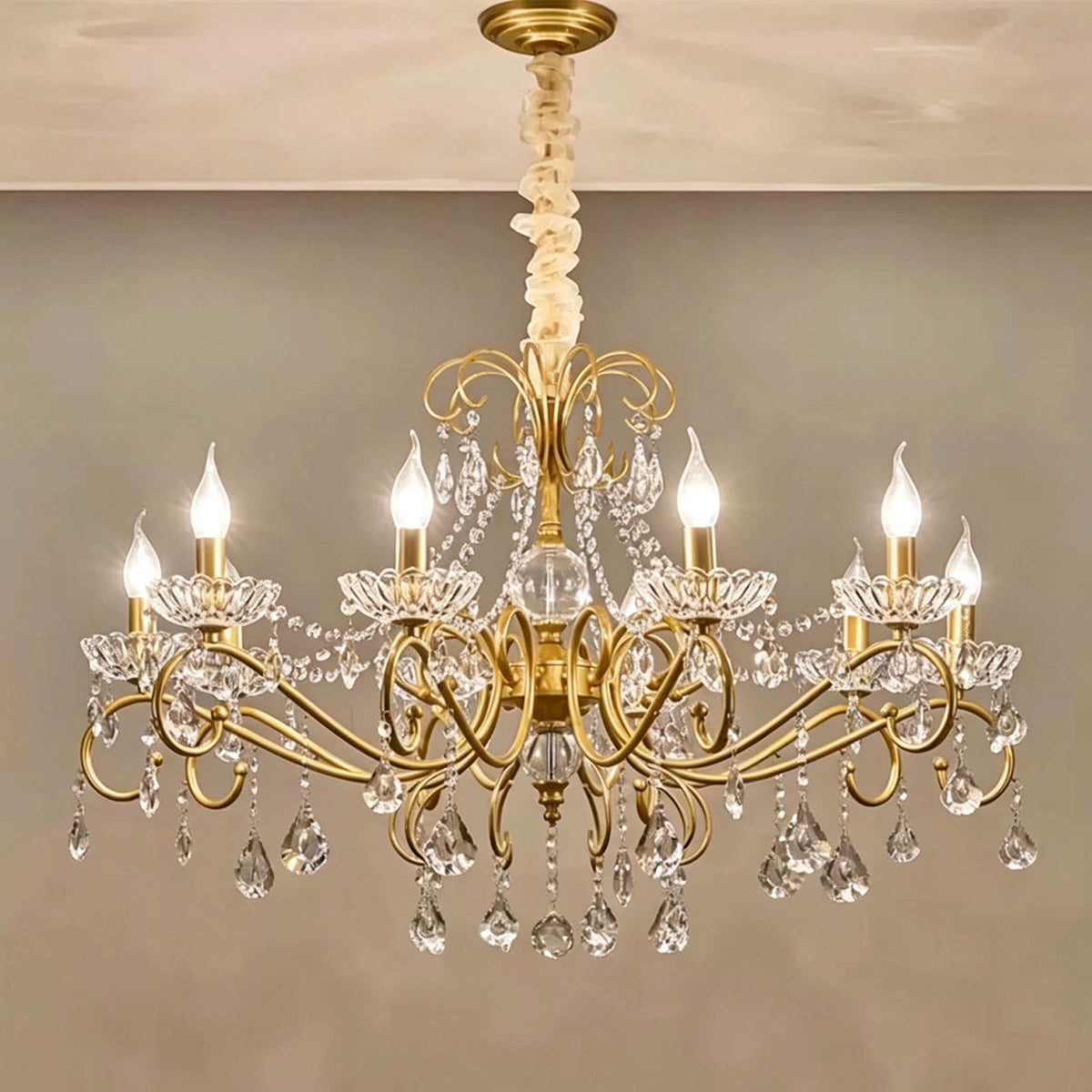 Torvald Scrolled Crystal Brass Chandelier | Cut Crystal and Brass | Large size variant illuminated full view against a warm neutral wall | Severn Lighting
