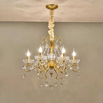 Torvald Scrolled Crystal Brass Chandelier | Cut Crystal and Brass | Compact size variant full view glowing brightly on a neutral backdrop | Severn Lighting