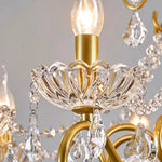 Torvald Scrolled Crystal Brass Chandelier | Cut Crystal and Brass | Close-up detail of the candle bulb, crystal bobeche, and brass arm | Severn Lighting