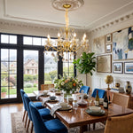 Torvald Scrolled Crystal Brass Chandelier | Cut Crystal and Brass | Suspended over a wooden dining table in a spacious elegant dining area | Severn Lighting
