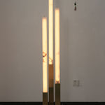 Trelune Column Floor Lamp | Alabaster and Brass | Three tiered columns illuminated against white room wall | Severn Lighting