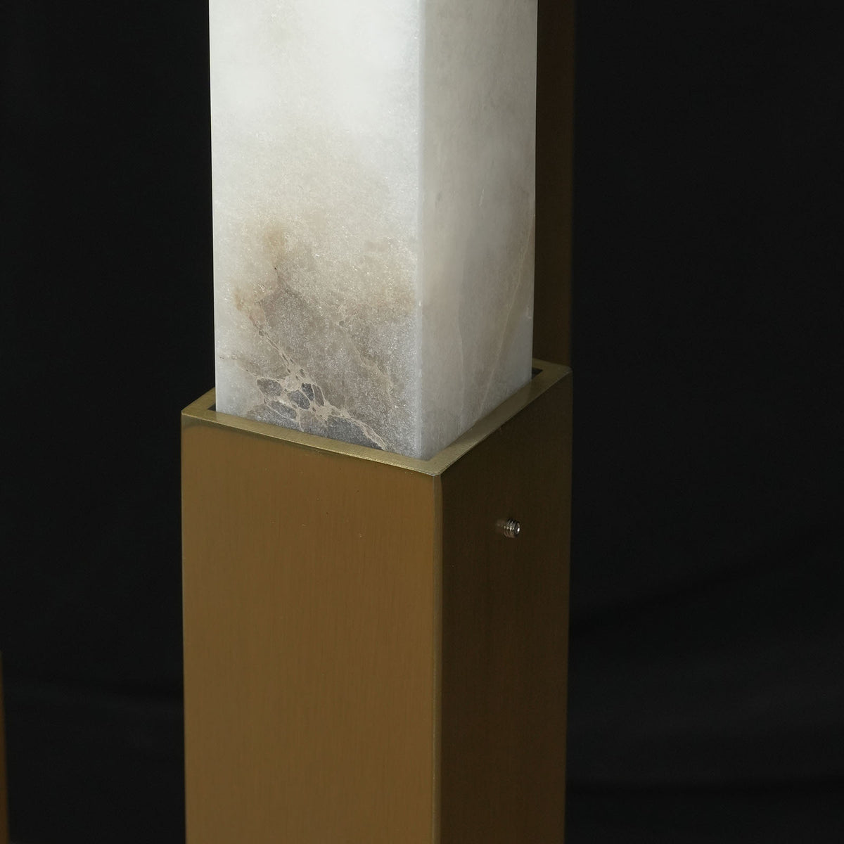 Trelune Column Floor Lamp | Alabaster and Brass | Close-up of square stone column resting in brass base | Severn Lighting