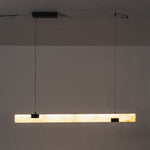 Vale Alabaster Linear Glow Pendant Lighting | Natural Alabaster and Black Metal | Horizontal studio view of the linear alabaster fixture fully lit against a dark background | Severn Lighting