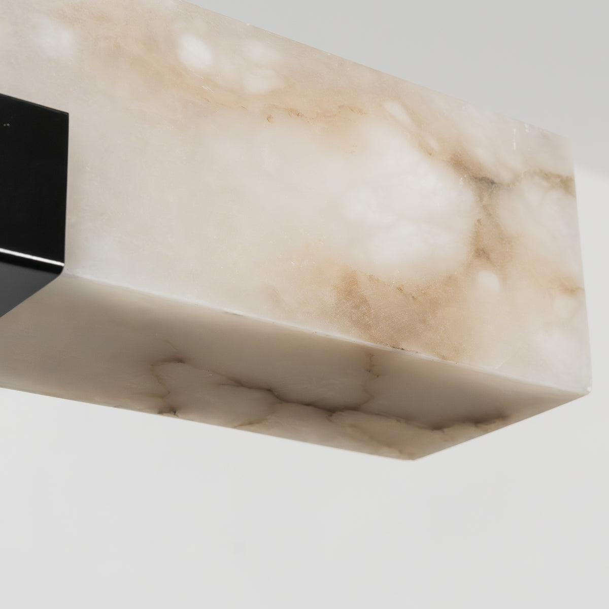 Vale Alabaster Linear Glow Pendant Lighting | Natural Alabaster and Black Metal | Close-up texture view showcasing the natural alabaster stone grain and black metal clamp | Severn Lighting