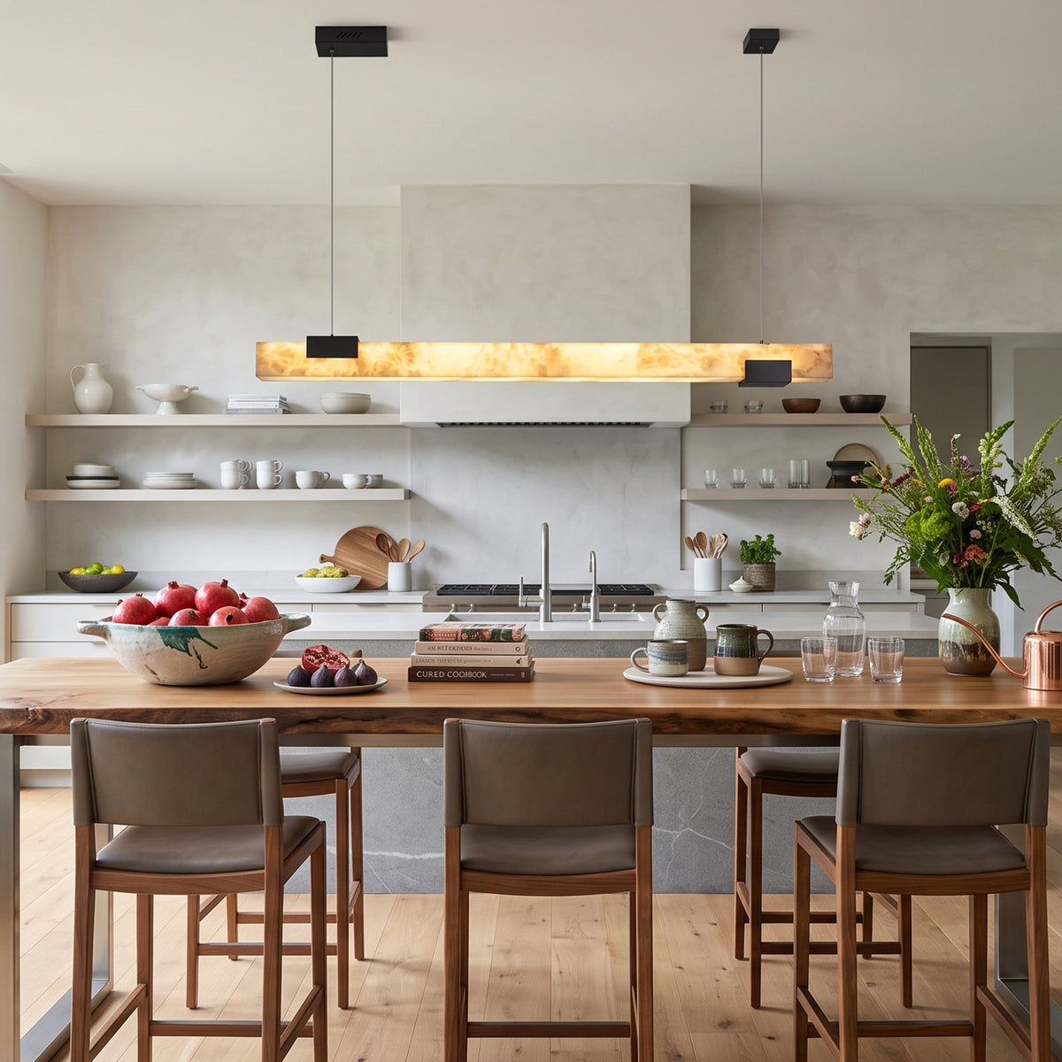 Vale Alabaster Linear Glow Pendant Lighting | Natural Alabaster and Black Metal | Suspended above a spacious wooden kitchen island counter with brown leather bar stools | Severn Lighting